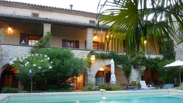 A pool area with a stone building, outdoor seating, and a well-lit entrance. - Spacious Mas 18th century,for 10 persons,  private pool, near Uzès (Belvézet)