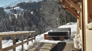 A wooden deck with a view of snow-covered mountains.
