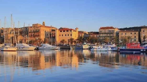 A marina with boats docked, buildings with red roofs, and palm trees. - SANA - CASA SULTANA (PROPRIANO)