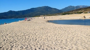 A beach with a clear sky, sandy shore, and mountains in the background. - SANA - CASA SULTANA (PROPRIANO)