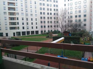 En bostadsbyggnad med flera våningar, balkonger och en lekplats med leksaker.