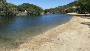 A river with clear water, surrounded by trees and a dirt path. - Private cabin on 10 acre lake with great bass fishing, 4.5 miles from Boerne (Boerne)