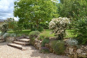 A garden with stone steps leading to a grassy area, surrounded by various plants and trees. - Le Gîte de Maëlle 4*15km from Beauval zoo in Saint-Aignan, Loire castles (fontguenand)