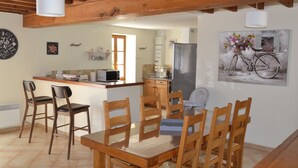 A kitchen with wooden chairs, a dining table, and a refrigerator.
