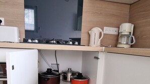 A compact kitchen with a gas stove, a coffee maker, and a kettle on the countertop. - SUNNY HOME / STUDIO ALL EQUIPPED (Cuges-Les-Pins)