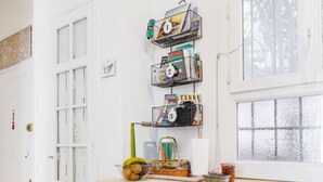 Una cucina con mobili bianchi, lavastoviglie integrata e una finestra vista alberi.