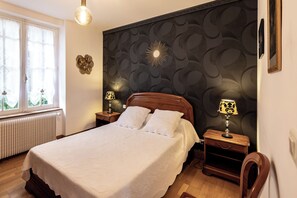 Een slaapkamer met een bed, twee nachtkastjes, een raam en een radiator.
