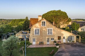 A stone house with a garden, a gazebo, and a view of the surrounding landscape. - Gite Les Bleuets - 12 pers. for get-togethers, near golf course (Saint-Geyrac)