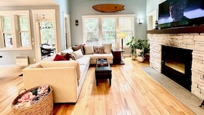 A spacious living room with a large fireplace, a comfortable sofa, and a television mounted above the fireplace. - 3 Bedroom Sleeps 6, Hot Tub, Exec home, Workspace incl. desk,  (Swansea Point)