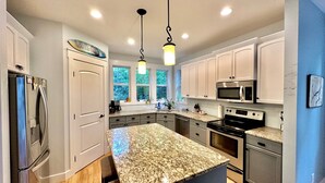 A modern kitchen with granite countertops, stainless steel appliances, and white cabinetry. - 3 Bedroom Sleeps 6, Hot Tub, Exec home, Workspace incl. desk,  (Swansea Point)
