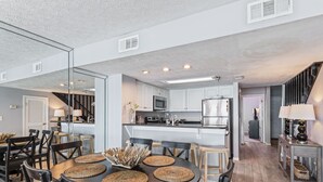 A modern kitchen with white cabinets, a stainless steel refrigerator, and a microwave. - EMERALD COAST PARADISE! 202 Destin Seafarer (Destin)