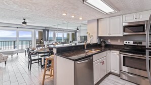 A modern kitchen with a large island, stainless steel appliances, and a view of the ocean. - EMERALD COAST PARADISE! 202 Destin Seafarer (Destin)