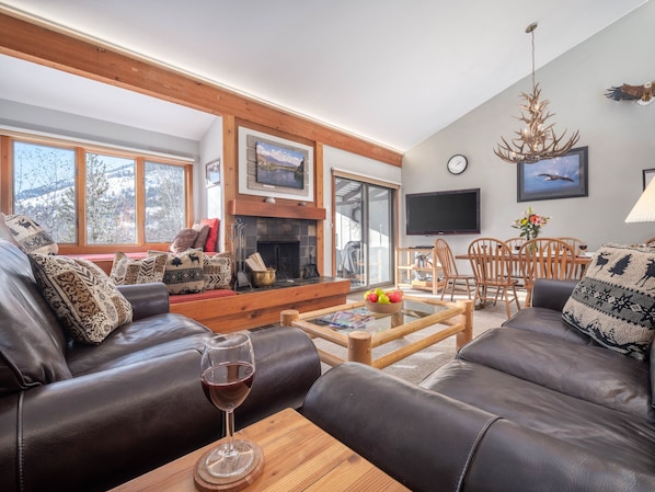 Relax by the fireplace in a comfortable seating area with leather sofas and a wooden coffee table.