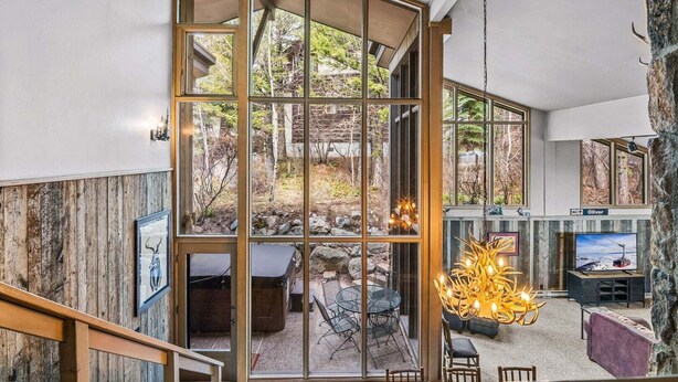 Un intérieur moderne avec une cloison en verre, des sièges en plein air et un mur en pierre.