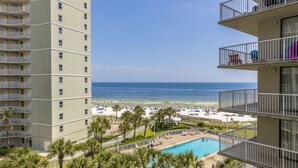 Un hôtel doté d'une piscine, offrant une vue sur la plage et comprenant plusieurs balcons.