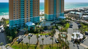Un hôtel composé de plusieurs immeubles de grande hauteur, doté d’un espace piscine et offrant une vue sur la plage.