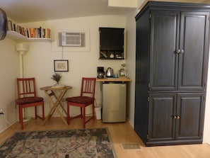 Cozy living space with a kitchenette, comfortable seating area, and a bookshelf.