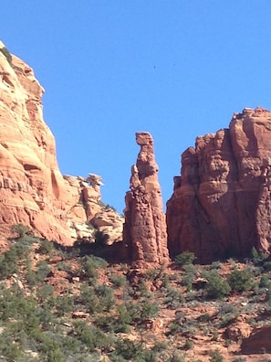 Natural rock formations stand amidst sparse vegetation in a serene landscape.