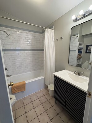 Un baño con una bañera blanca, un lavabo, un inodoro y un espejo.