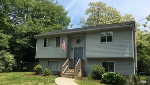 A two-story house with a front porch, a small front yard, and a driveway.