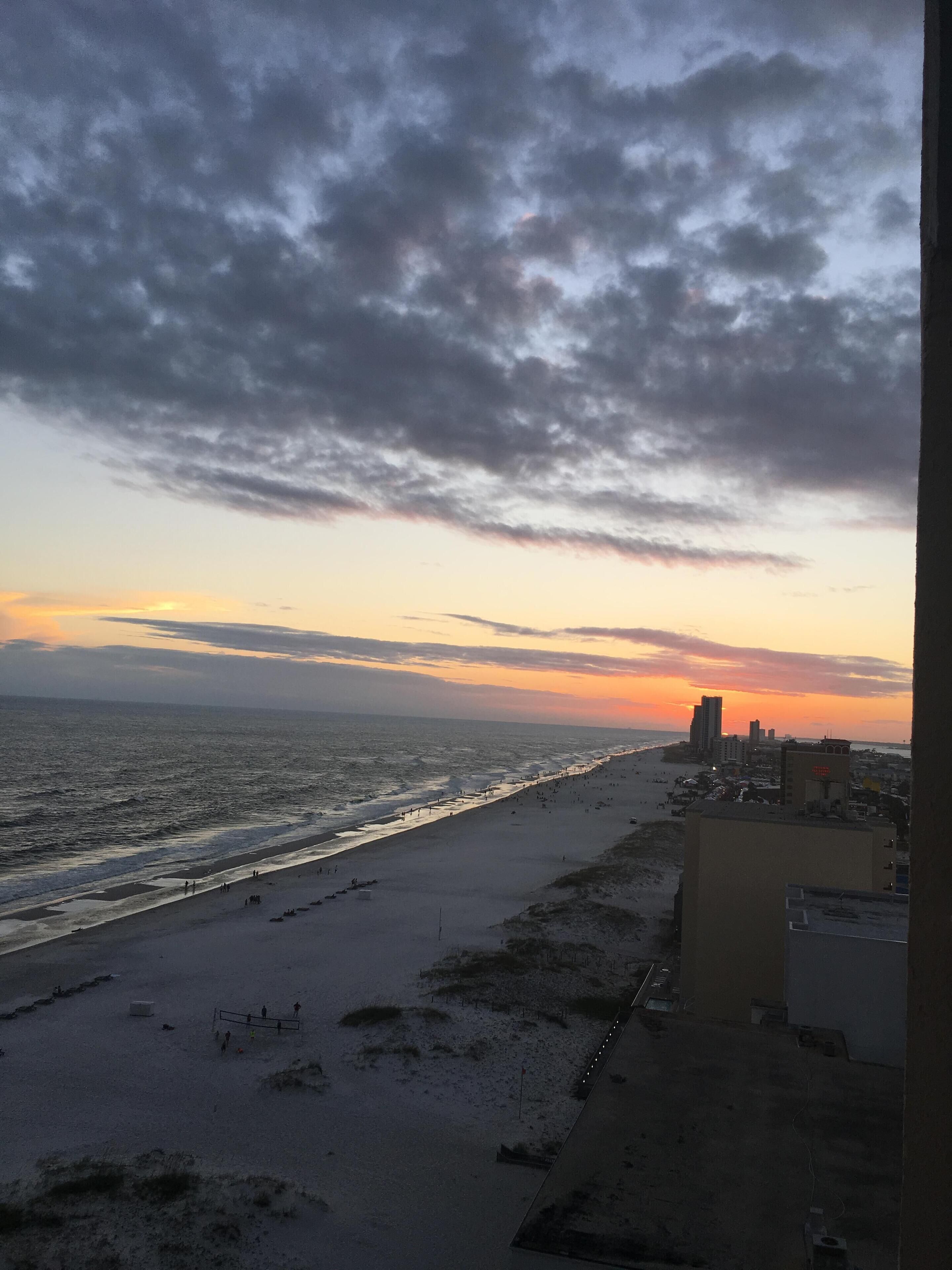 Ein Strand mit Blick auf den Ozean und eine Stadtansicht in der Ferne.