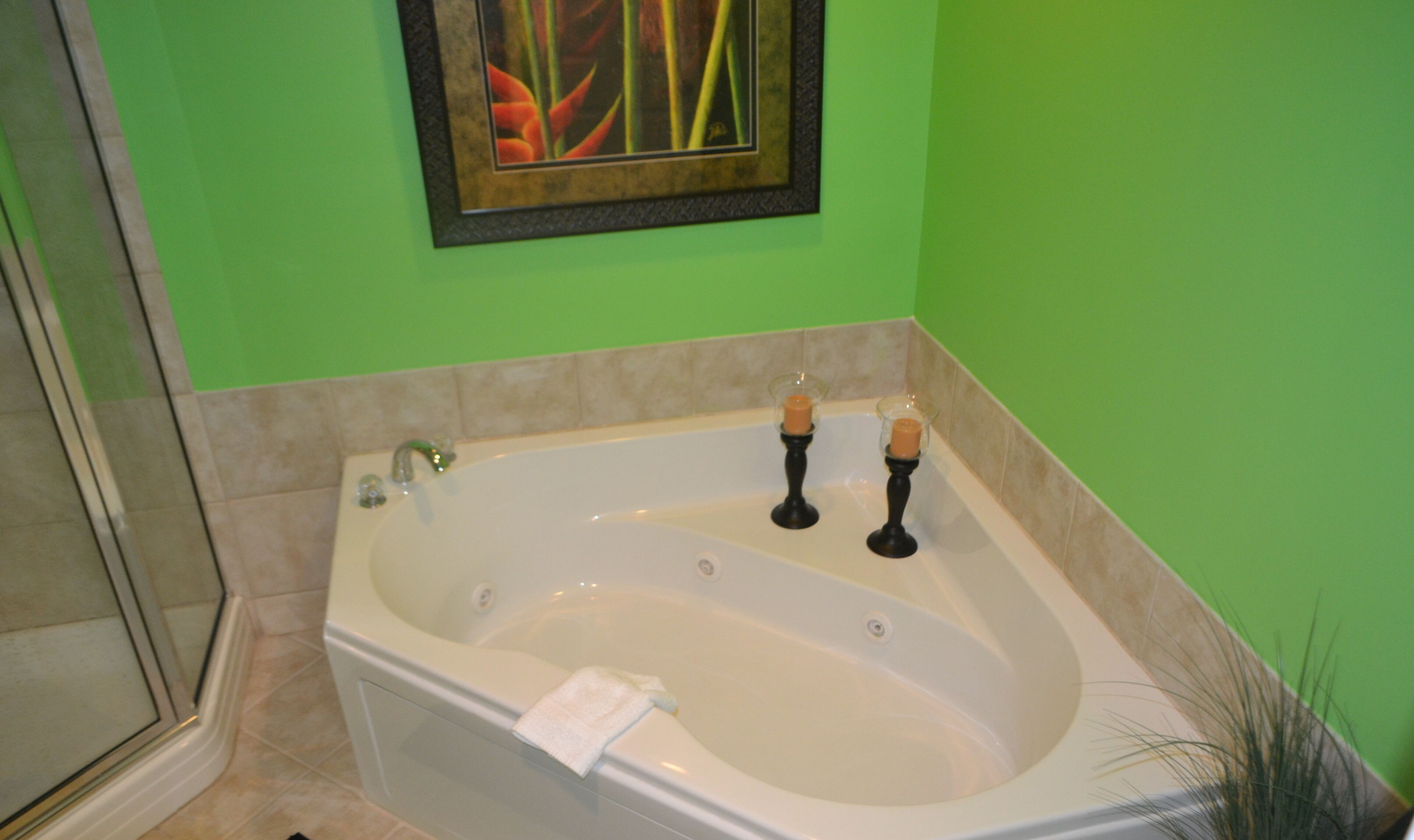 Ein Badezimmer mit einer großen Badewanne, einer Dusche und einer grünen Wand.