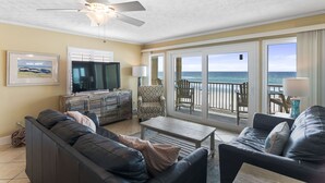 A living room with a sofa, coffee table, and a television. There is a balcony with a view of the ocean. - BREATHTAKING VIEWS on every floor! 214 Destin Seafarer (Destin)