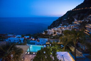 A coastal resort with a swimming pool, beachfront villas, and a view of the sea.