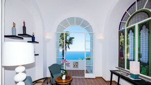 A room with a view of the sea, a chair, a table with a vase, and a lamp. - The Most Panoramic Villa In The Center Of Positano (Positano)