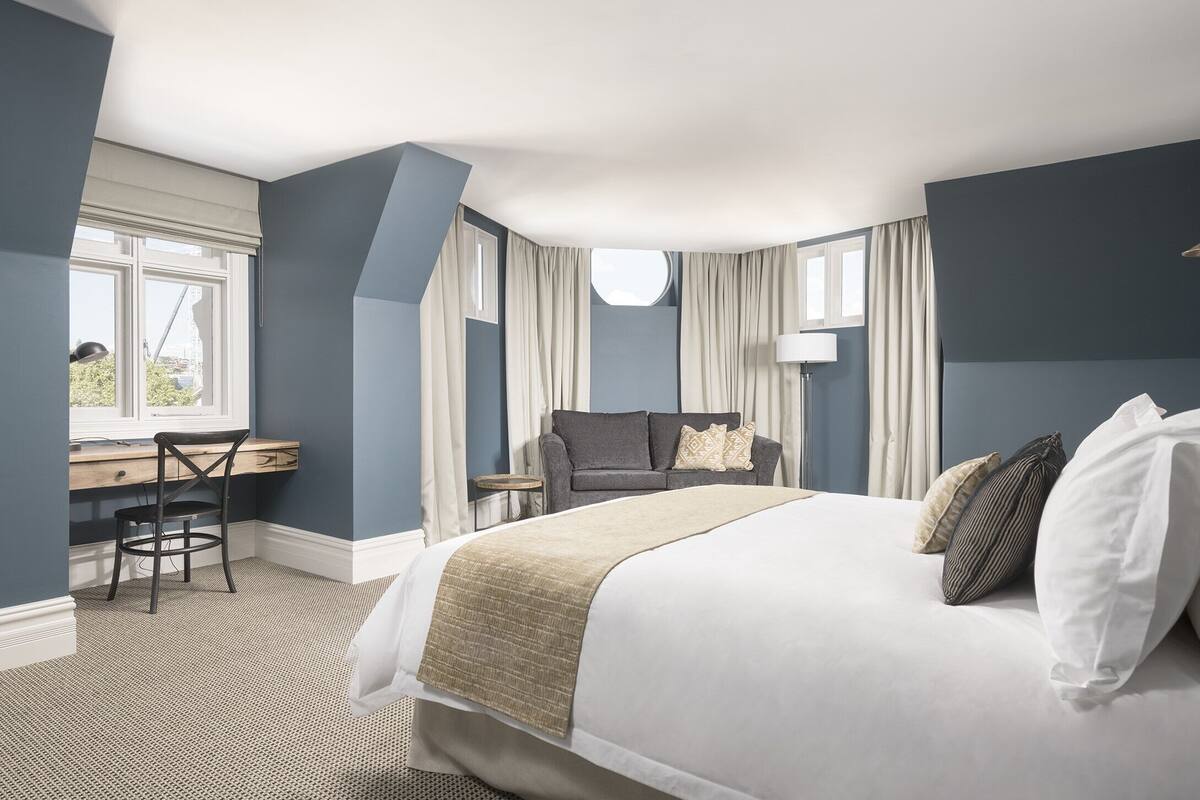 Une chambre d’hôtel avec un lit, un bureau et une chaise.