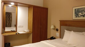 Comfortable accommodations feature a large wardrobe, bedside table, and a bed with crisp linens.