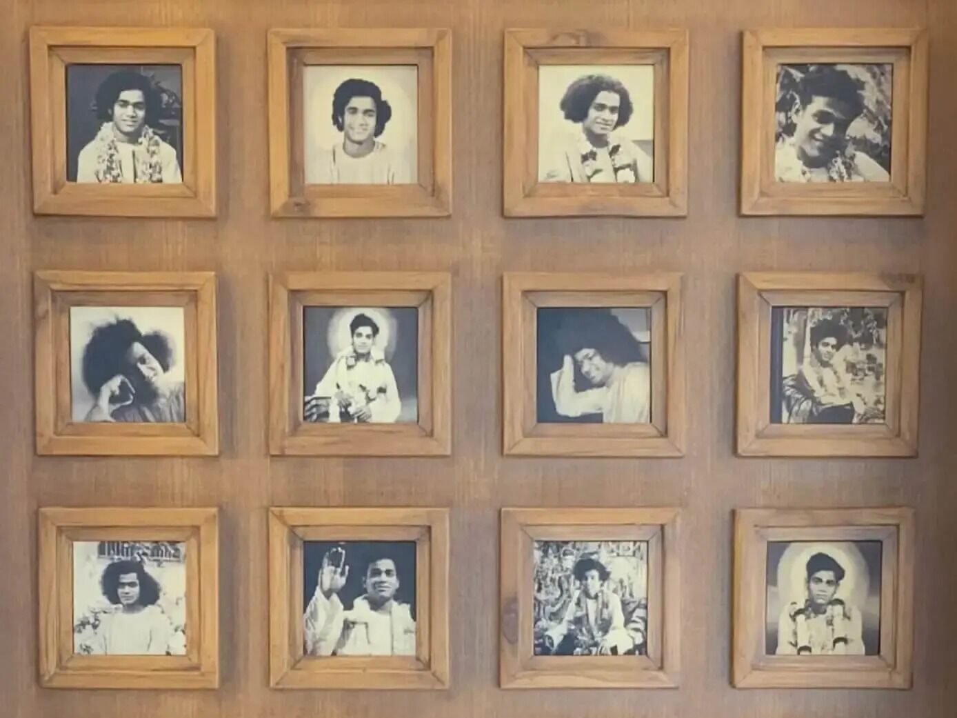 A wall with multiple framed photographs arranged in a grid pattern.