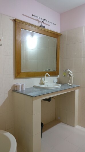 Bathroom features a sink, mirror, and towel dispenser.