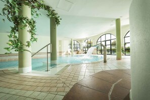 Una piscina techada, sillones reclinables de piscina