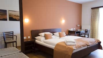 Une chambre d’hôtel bien rangée, avec un lit, un bureau et une chaise.