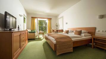 A hotel room with a bed, a TV, a desk, and a chair.