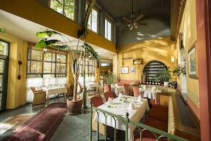 A restaurant with high ceilings, large windows, and a variety of seating options including tables and booths.