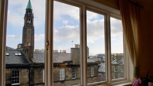 A window with a view of historic buildings and a tower. - Sophisticated Edinburgh Apartment in City Centre (Edinburgh)