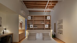 A bedroom with a bed, bedside tables, a wardrobe, and a built-in bookshelf. - Massimago Wine Suites (Verona)