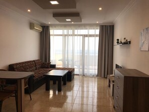 Familieleilighet, 1 soverom, kjøkken, ved strandkanten | Oppholdsområde | Flatskjerm-TV