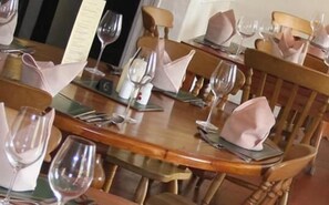 A dining table set with wine glasses, plates, and cutlery, ready for a meal.
