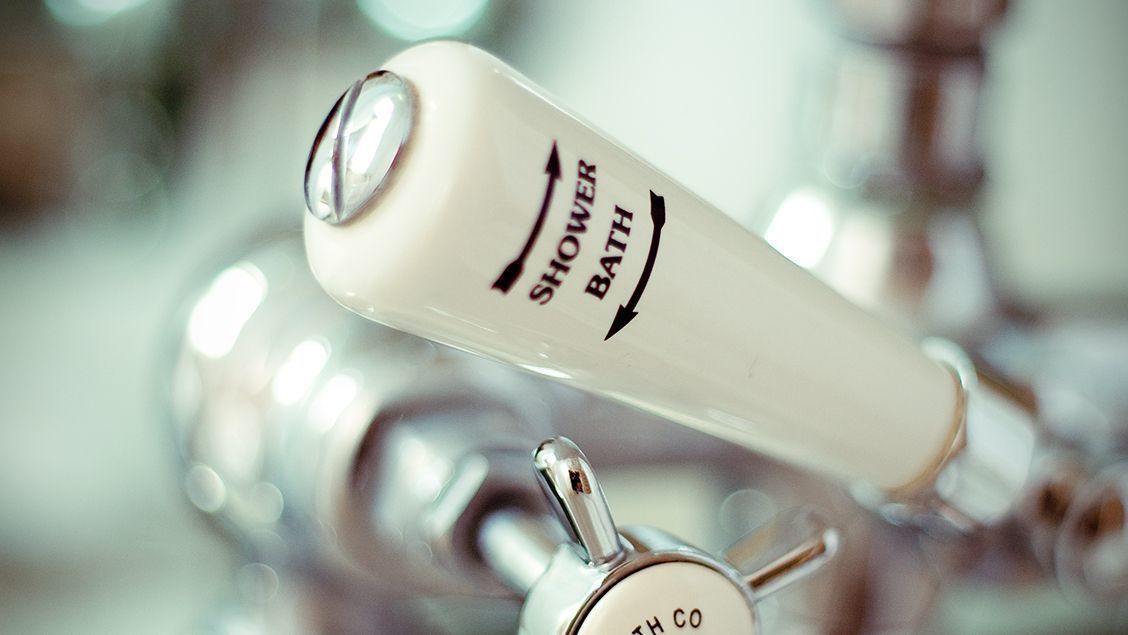 A shower control knob with the words "SHOWER BATH" and "BATH CO" on it.