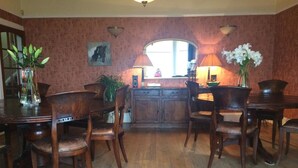 A dining area with wooden furniture, a mirror, and a window. - Broom Lodge (Largs)