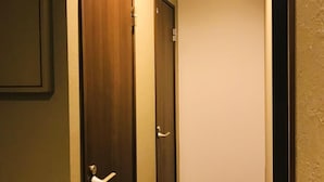 A hallway with two wooden doors, one with a handle and the other with a latch. - POPTONE the Guest House - Hostel (Hiroshima)