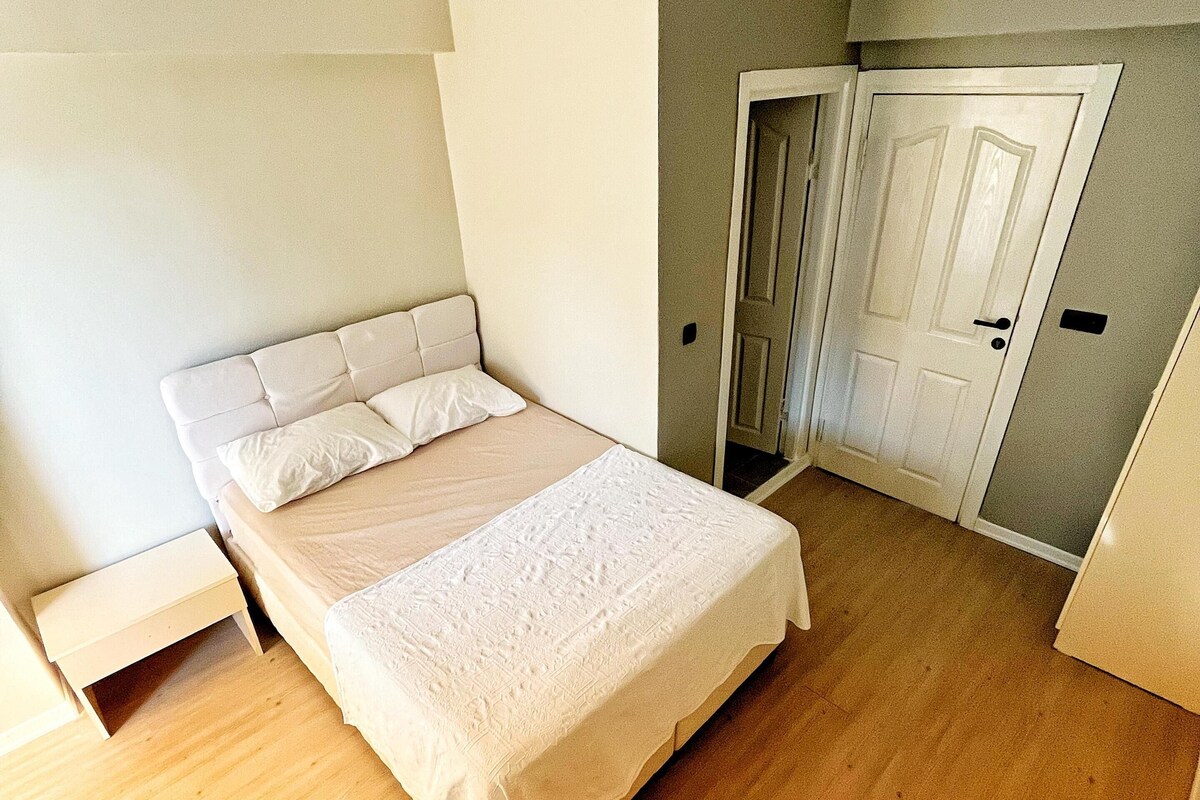 Ein Schlafzimmer mit Bett, Nachttisch, Tür und Kleiderschrank.