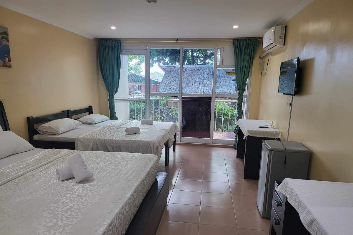 Habitación cuádruple Deluxe | Escritorio y ropa de cama