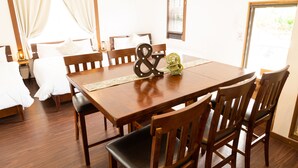 A dining area with a wooden table, chairs, and a decorative centerpiece. - Pine House in Churaumi (Motobu)