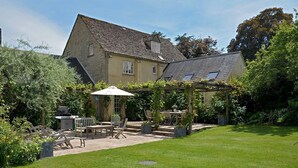 A house with a patio area, outdoor furniture, and a pergola. - Weir Cottage (Chipping Norton)