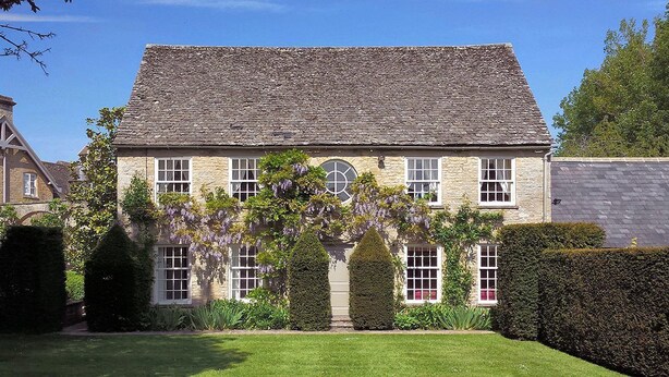 A stone building with a symmetrical facade, multiple windows, and a central arched window. - Weir Cottage (Chipping Norton)