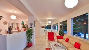 A spacious living area with a sofa, red chairs, a coffee table, and a reception desk.
